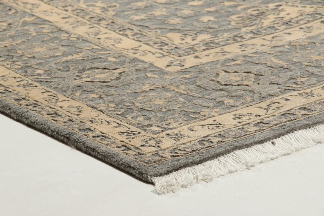 Et håndknyttet Tabriz-tæppe fra Indien med et indviklet blomstermønster i mørkegrå og beige.