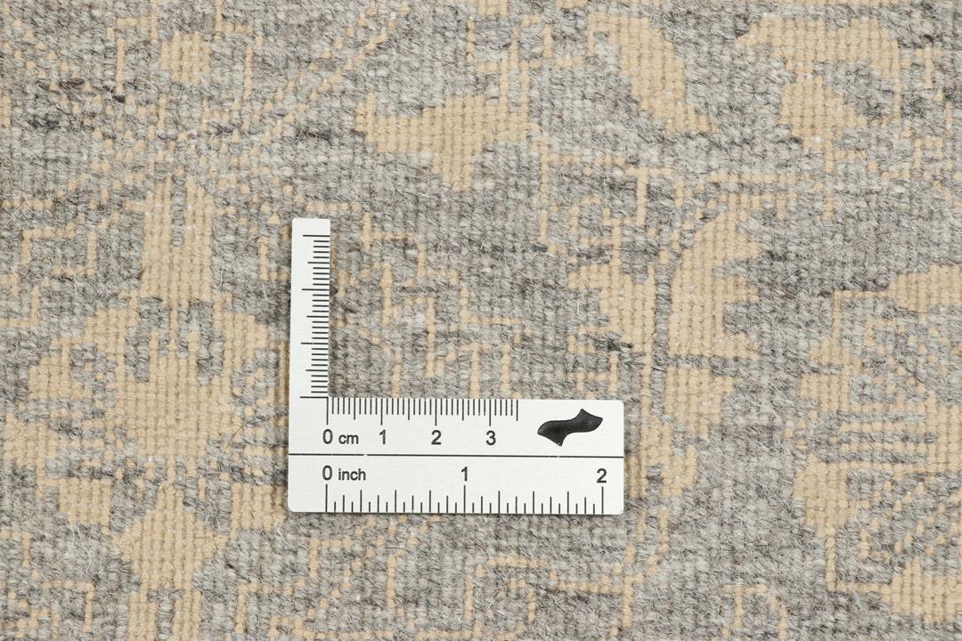 Et håndknyttet Tabriz-tæppe fra Indien med et indviklet blomstermønster i mørkegrå og beige.
