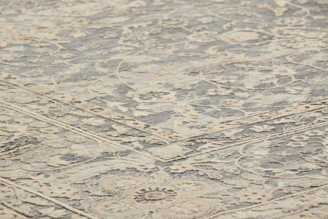 Et håndknyttet Tabriz-tæppe fra Indien med et indviklet blomstermønster i mørkegrå og beige.