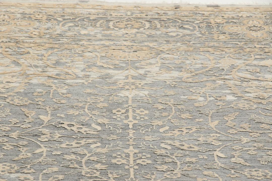 Et håndknyttet Tabriz-tæppe fra Indien med et indviklet blomstermønster i mørkegrå og beige.