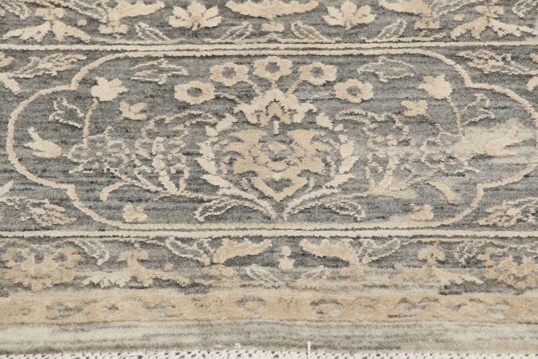 Et håndknyttet Tabriz-tæppe fra Indien med et indviklet blomstermønster i mørkegrå og beige.
