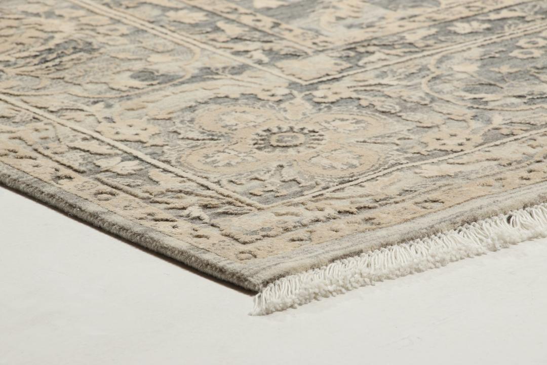 Et håndknyttet Tabriz-tæppe fra Indien med et indviklet blomstermønster i mørkegrå og beige.