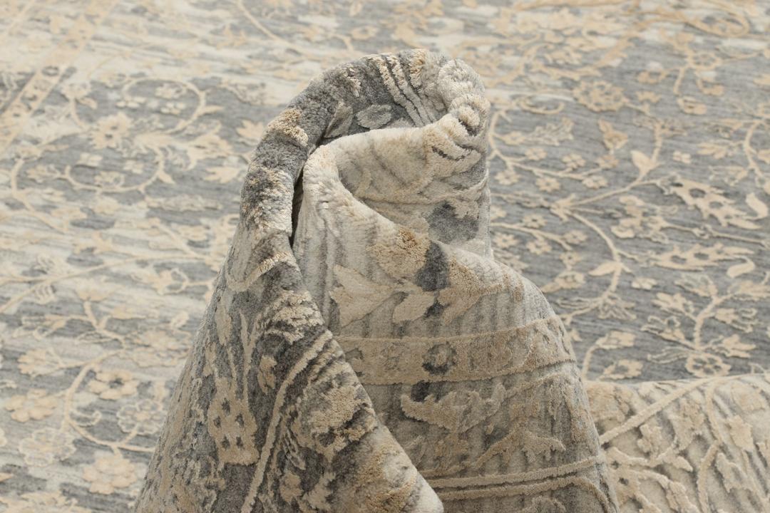 Et håndknyttet Tabriz-tæppe fra Indien med et indviklet blomstermønster i mørkegrå og beige.