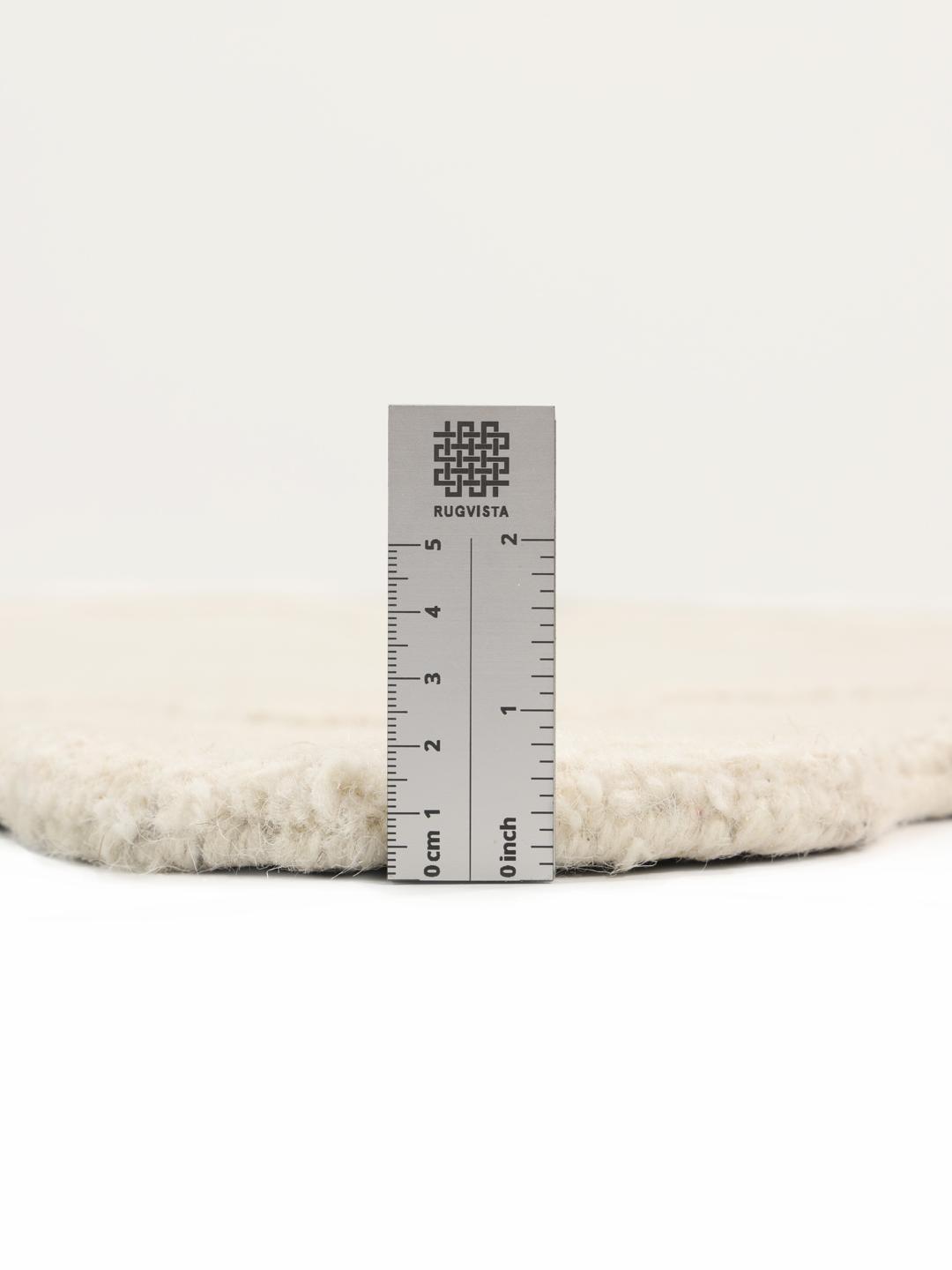 Tapis blanc cassé avec une surface texturée et un bord festonné
