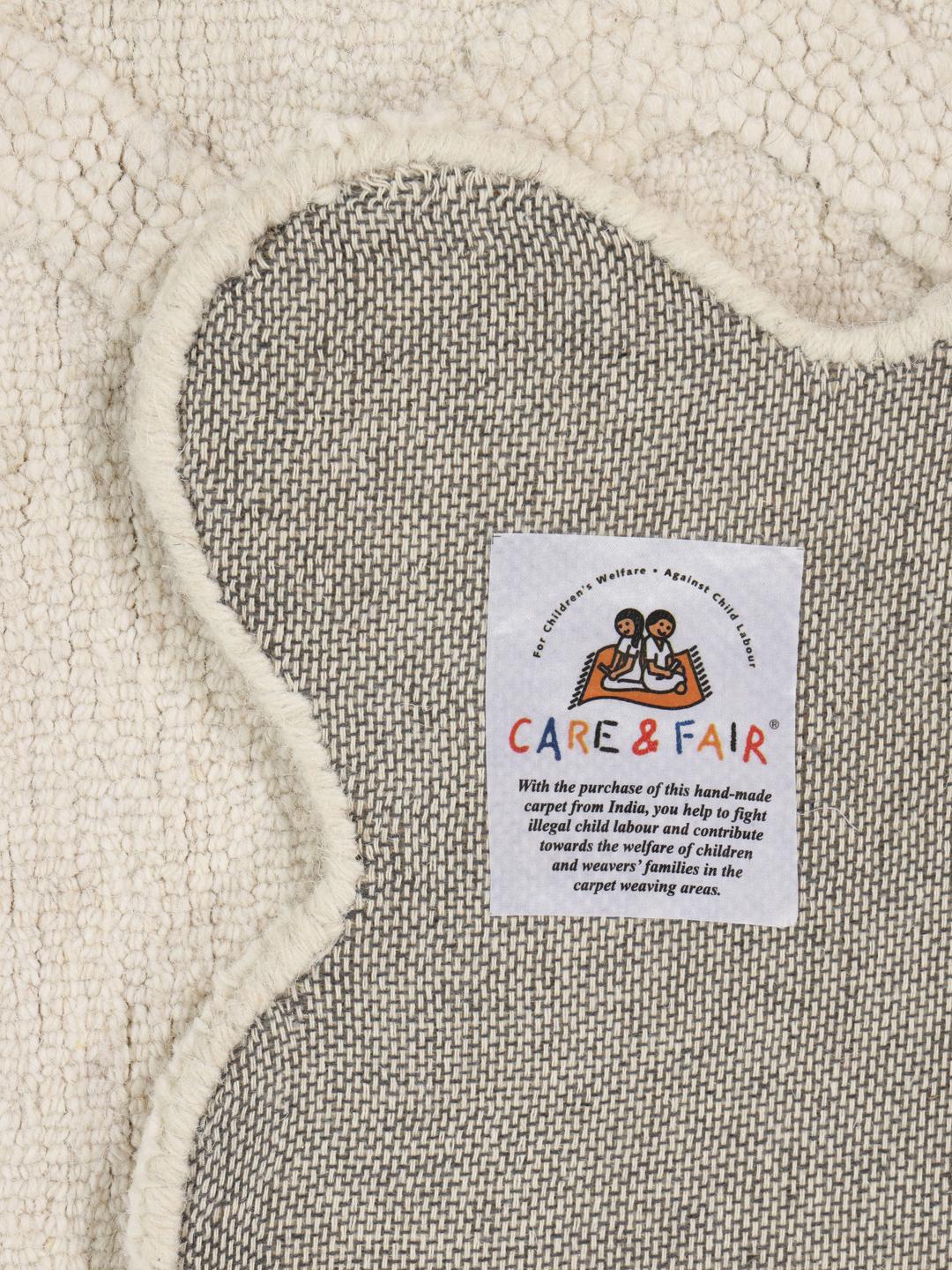 Off-white vloerkleed met een gestructureerd oppervlak en een geschulpte rand