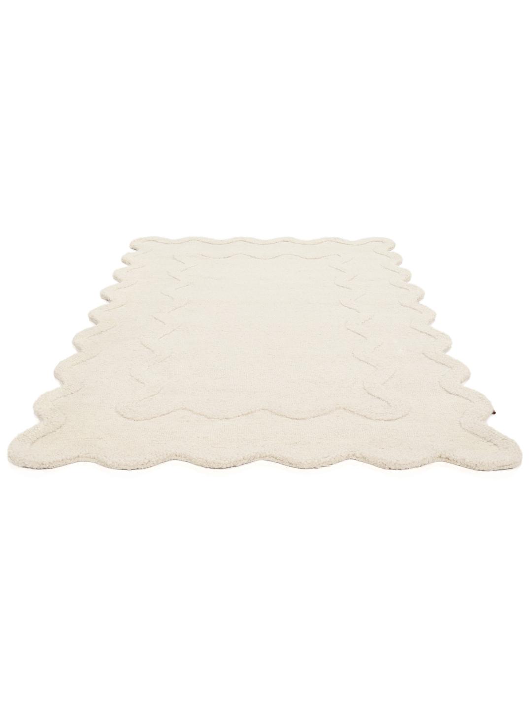 Tapis blanc cassé avec une surface texturée et un bord festonné