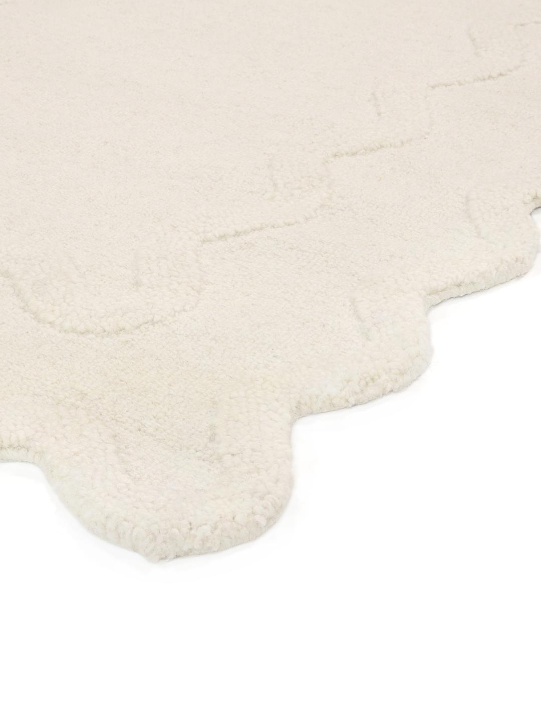 Tapis blanc cassé avec une surface texturée et un bord festonné