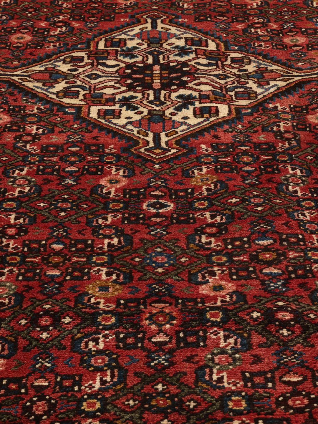 Hand-knotted Hosseinabad Wool rug from the Middle East in deep red