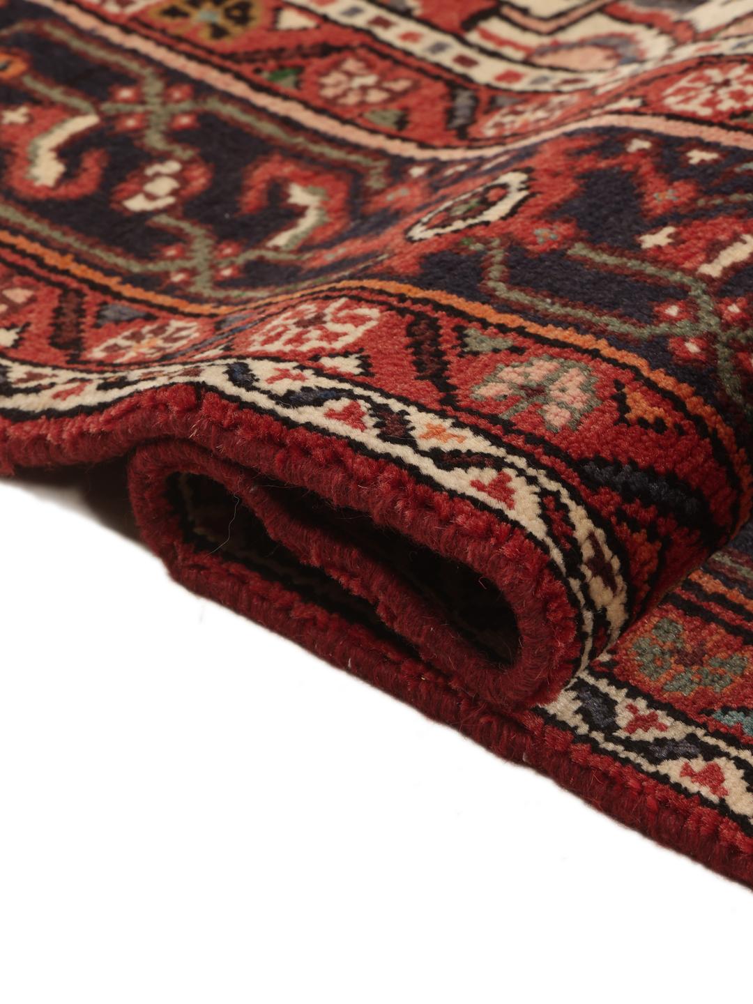 Hand-knotted Hosseinabad rug from the Middle East in deep red and dark blue tones.