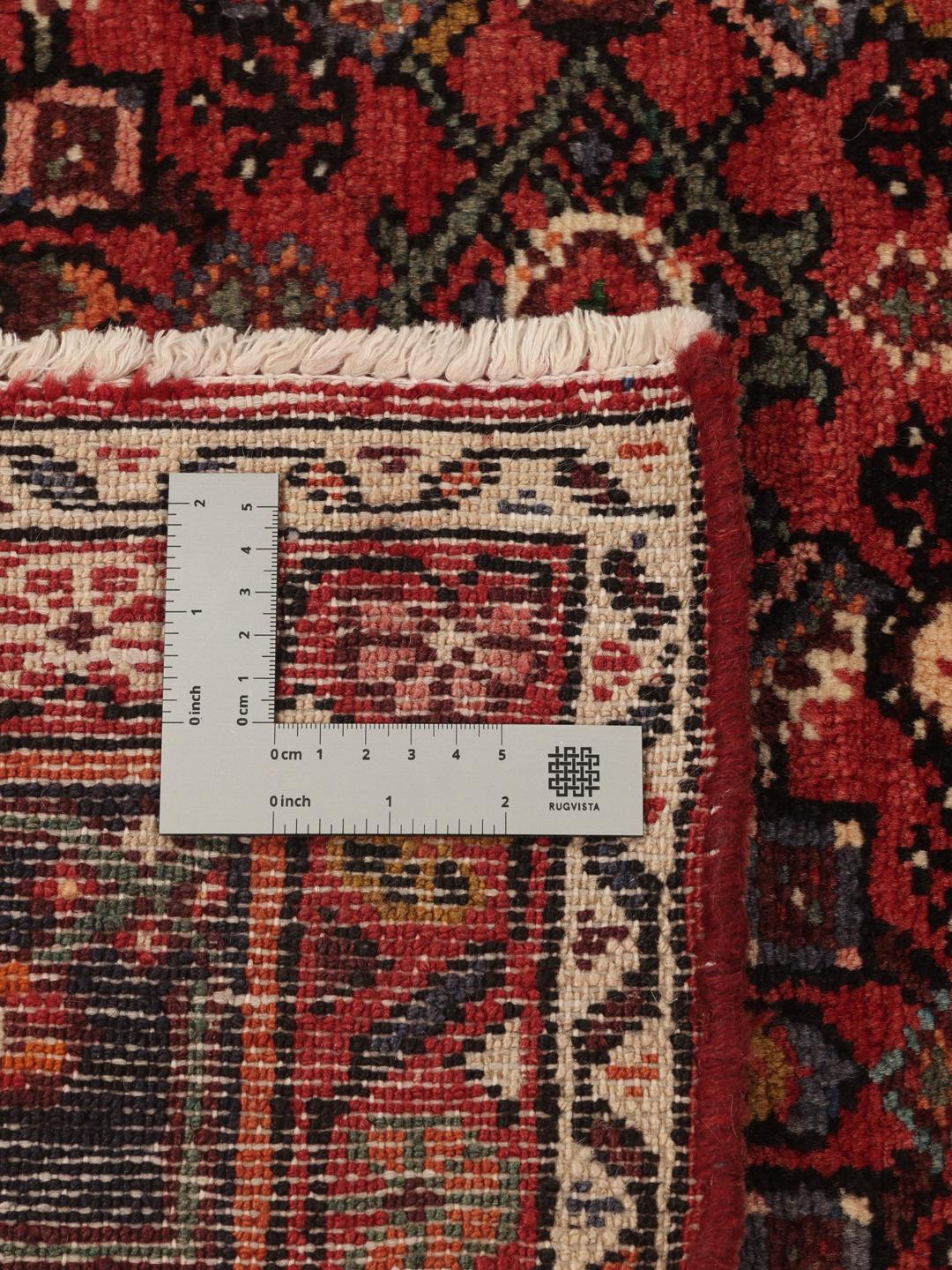Hand-knotted Hosseinabad rug from the Middle East in deep red and dark blue tones.