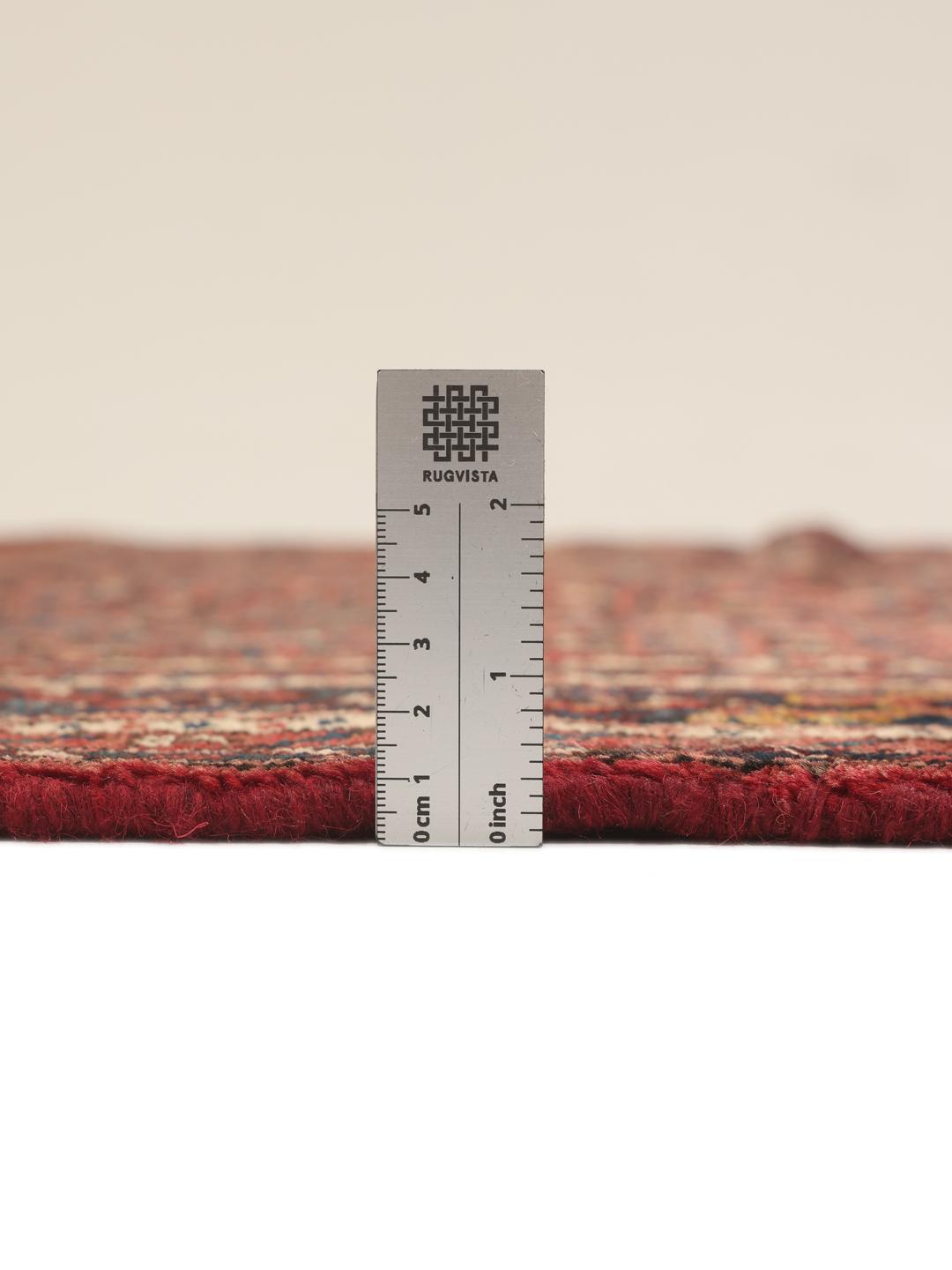 A hand-knotted Hosseinabad rug featuring a traditional dark-red field and detailed patterns.