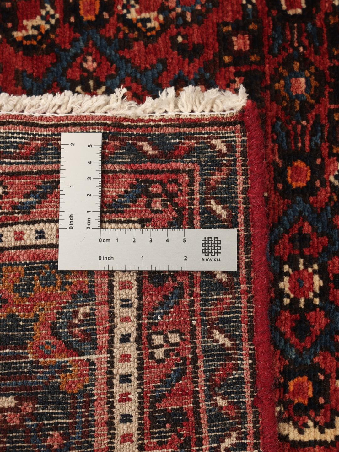 A hand-knotted Hosseinabad rug featuring a traditional dark-red field and detailed patterns.