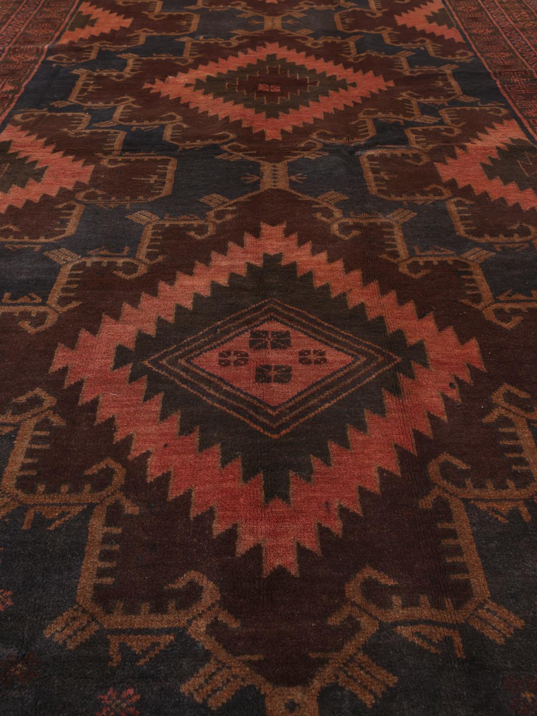 Ręcznie wiązany dywan Baluch z Afganistanu z głębokimi czerwonymi i czarnymi wzorami geometrycznymi.