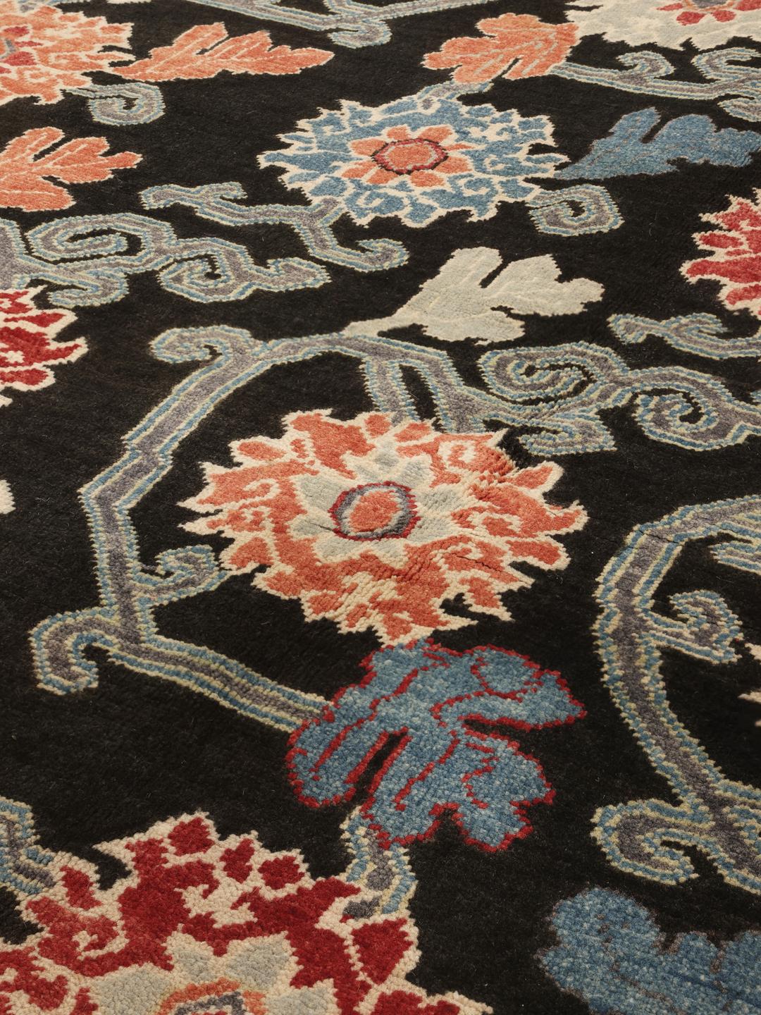 Hand-knotted Afghan Kazak rug with floral patterns on a black field
