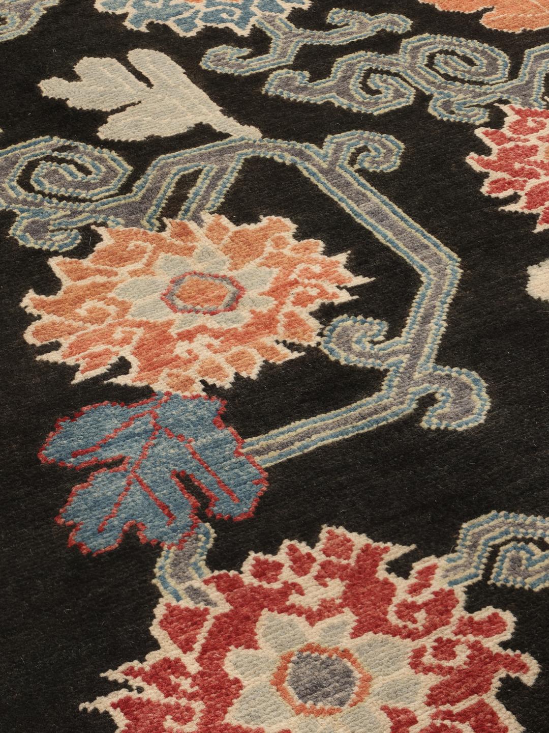 Hand-knotted Afghan Kazak rug with floral patterns on a black field