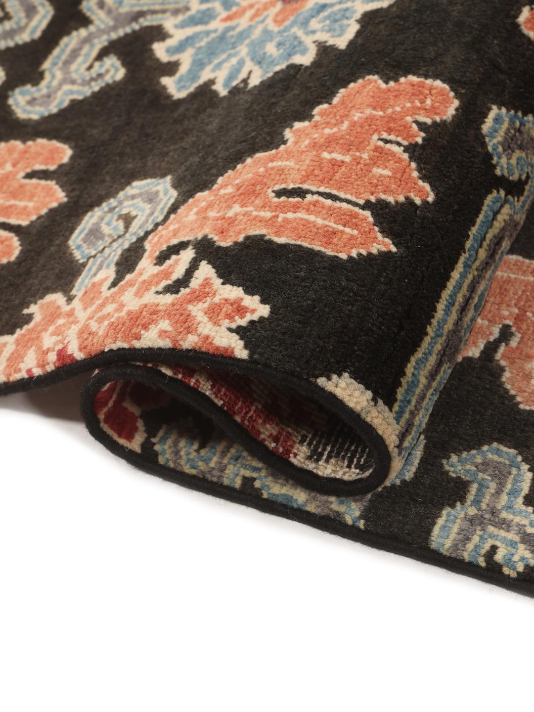 Hand-knotted Afghan Kazak rug with floral patterns on a black field