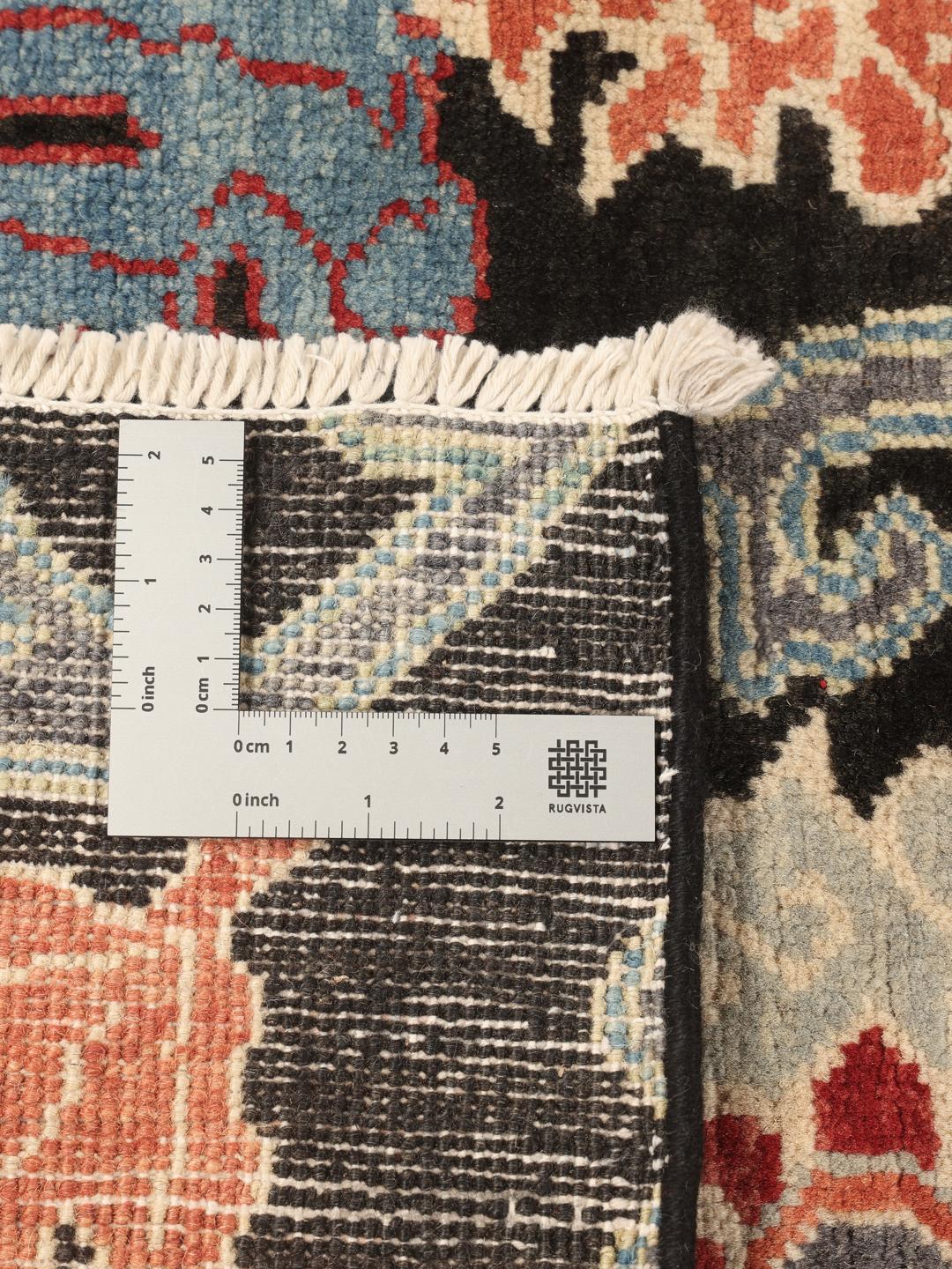 Hand-knotted Afghan Kazak rug with floral patterns on a black field