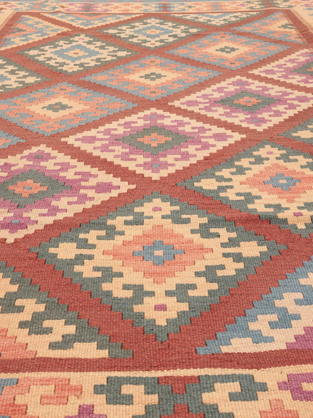 A hand-woven multicolor Kelim Ghashghai rug with geometric diamond patterns.