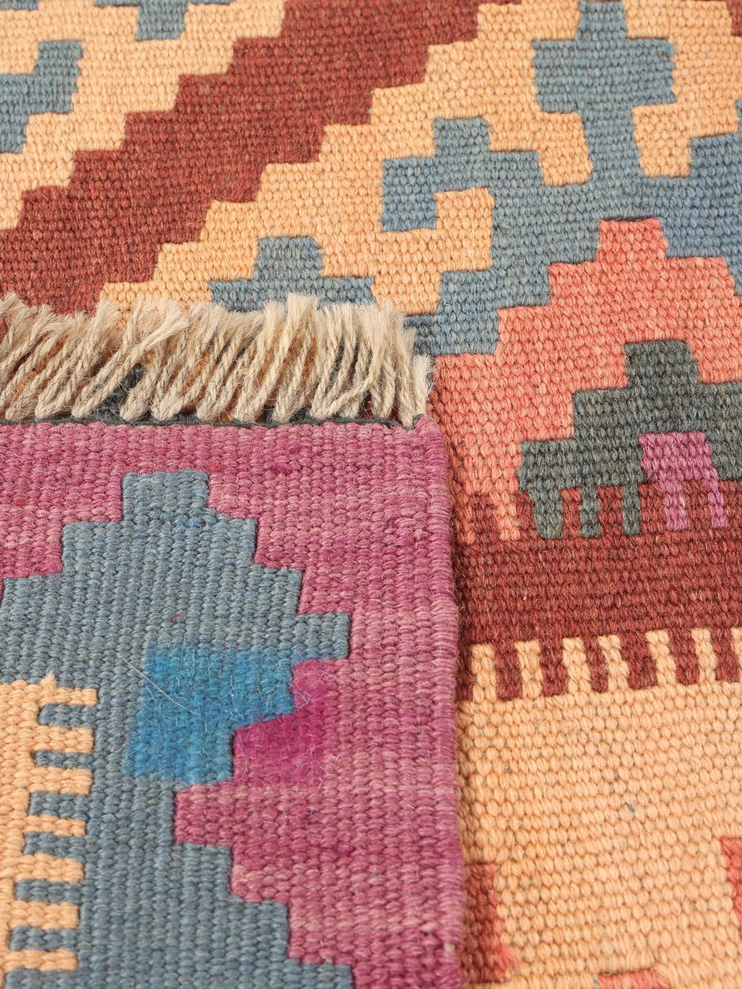 A hand-woven multicolor Kelim Ghashghai rug with geometric diamond patterns.