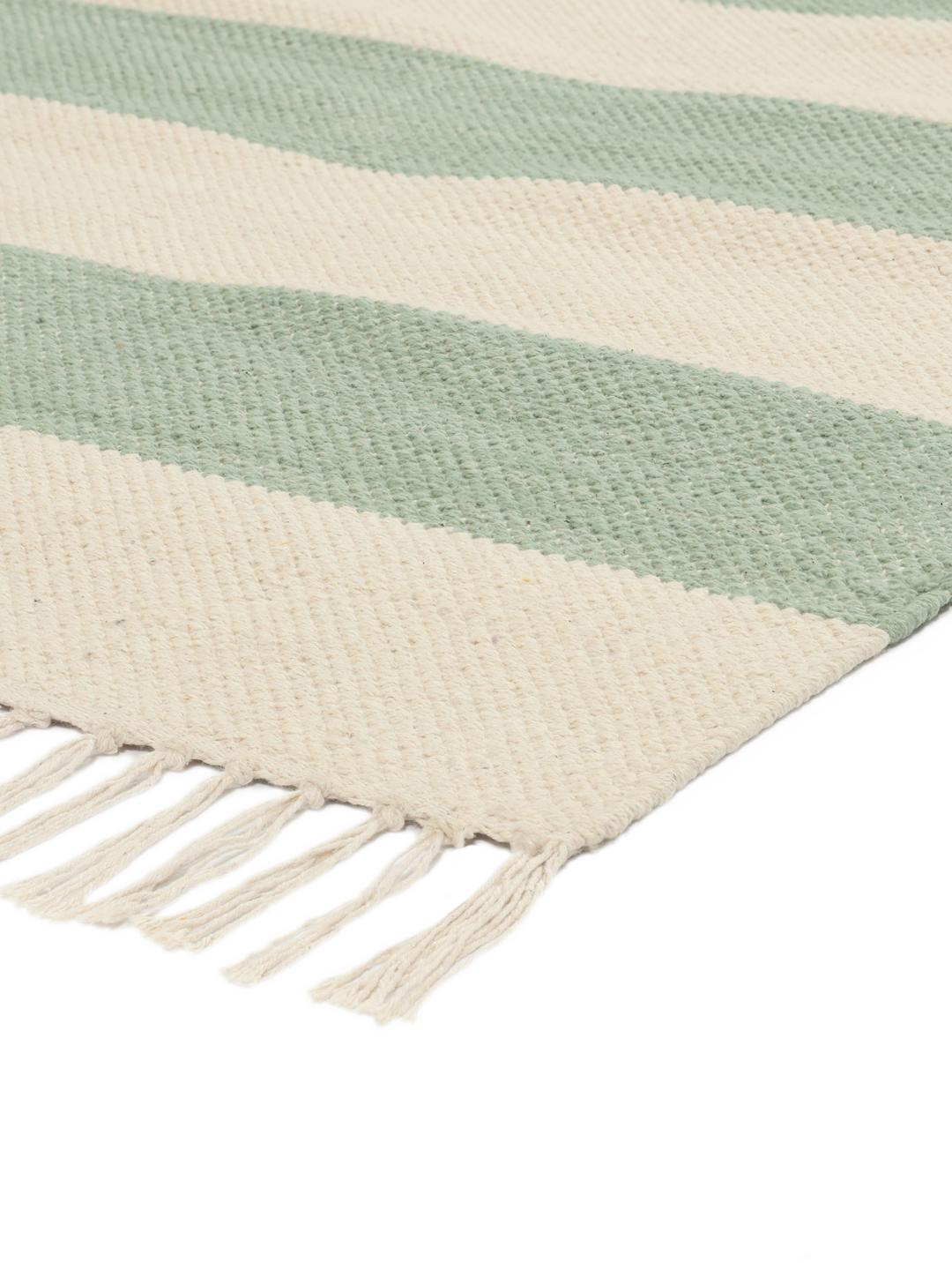 A hand-woven cotton rug featuring a mint green and cream striped pattern with fringe ends.