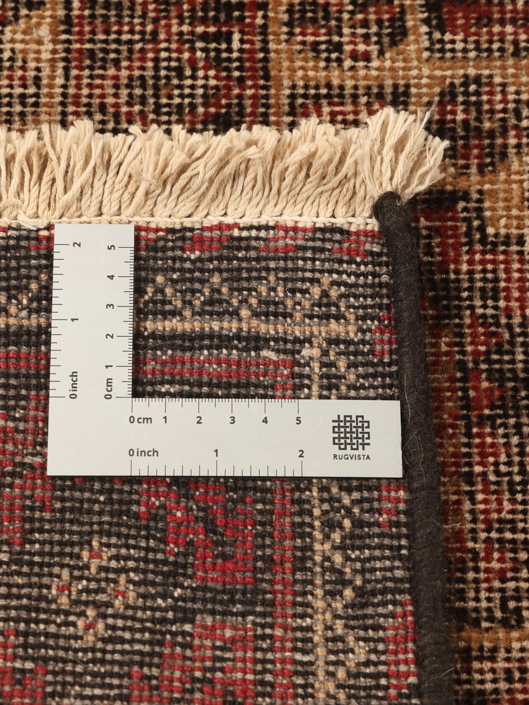 Håndknyttet Beluch-tæppe med en mørkerød patina og traditionelle geometriske motiver.