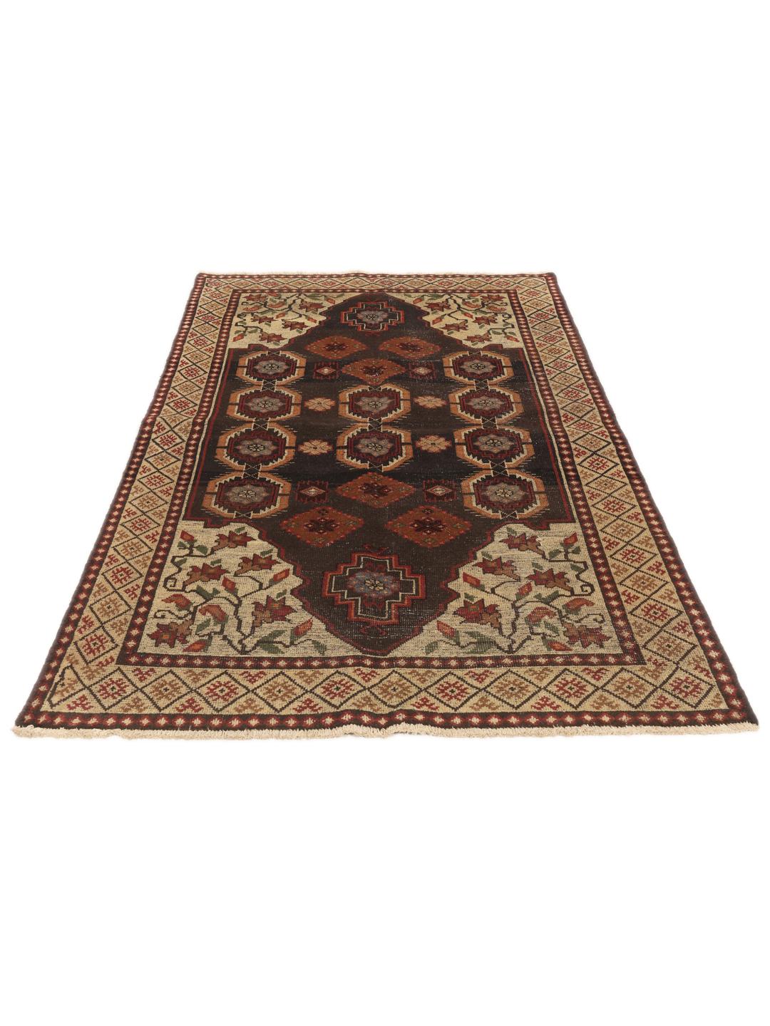 Een handgeknoopt tapijt uit het Midden-Oosten met een donker centraal medaillon en bloemrijke hoeken in tinten rood, beige en blauw.