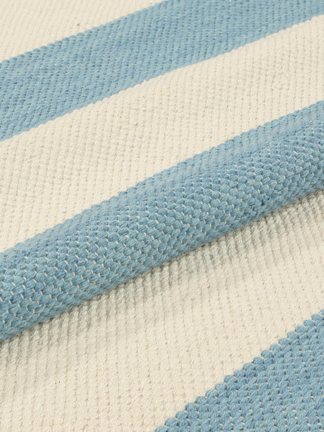 Tapis bleu clair orné d'un motif rayé épuré et de bords à franges