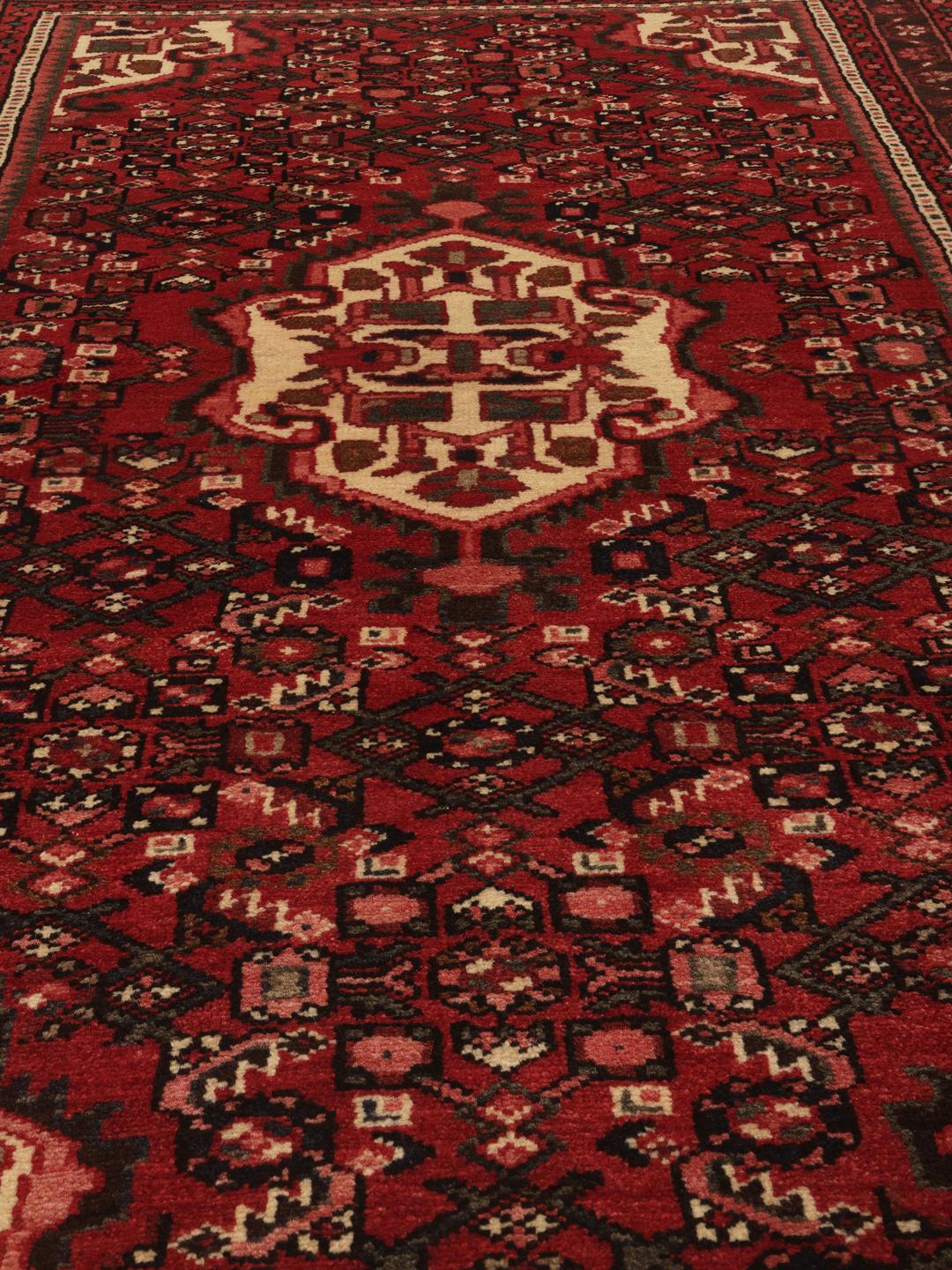 Tapis Hosseinabad noué à la main provenant du Moyen-Orient dans des tons de rouge et rouge foncé