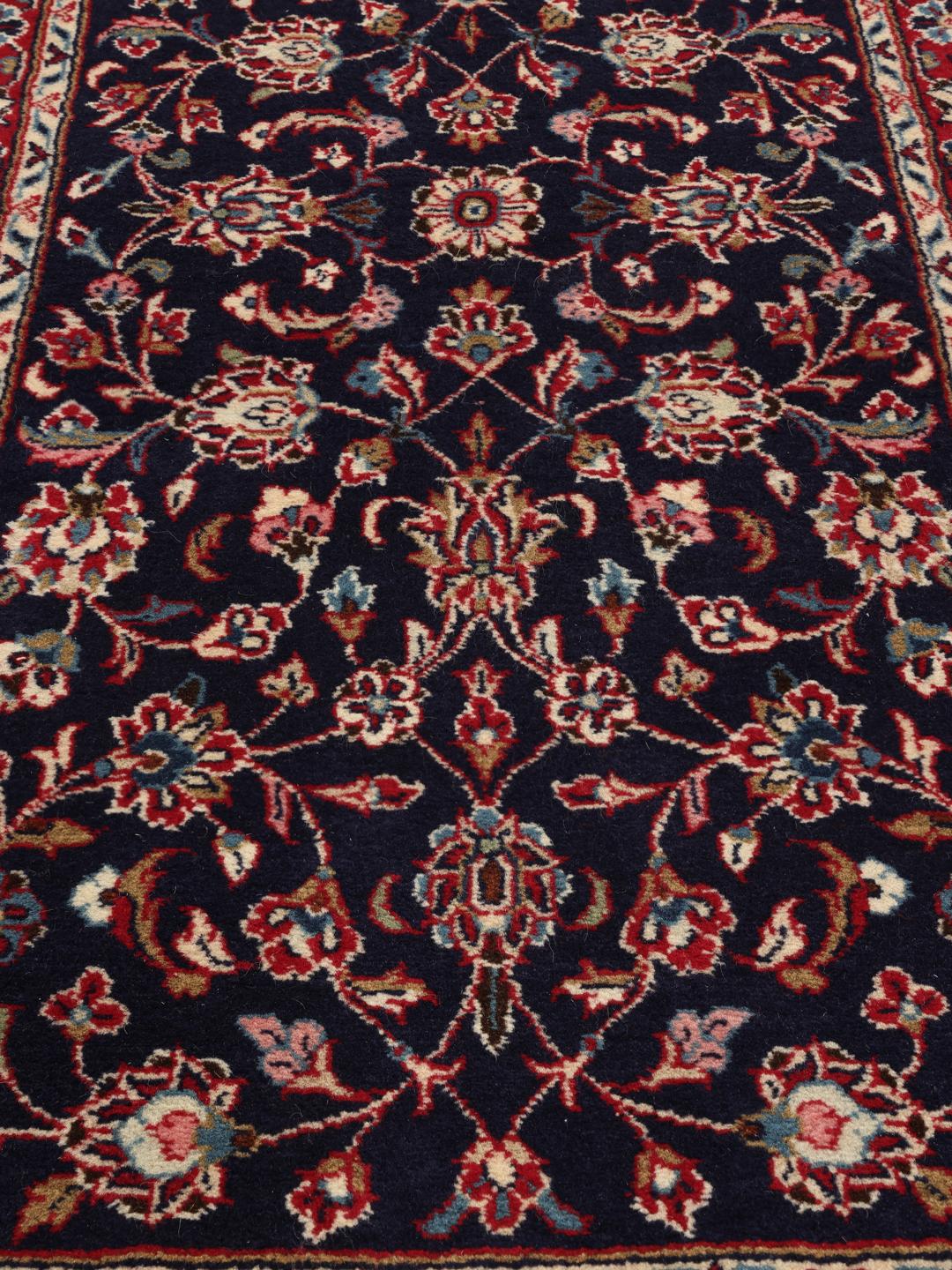 Un tapis de couloir Yazd du Moyen-Orient noué à la main avec un motif floral bleu foncé.
