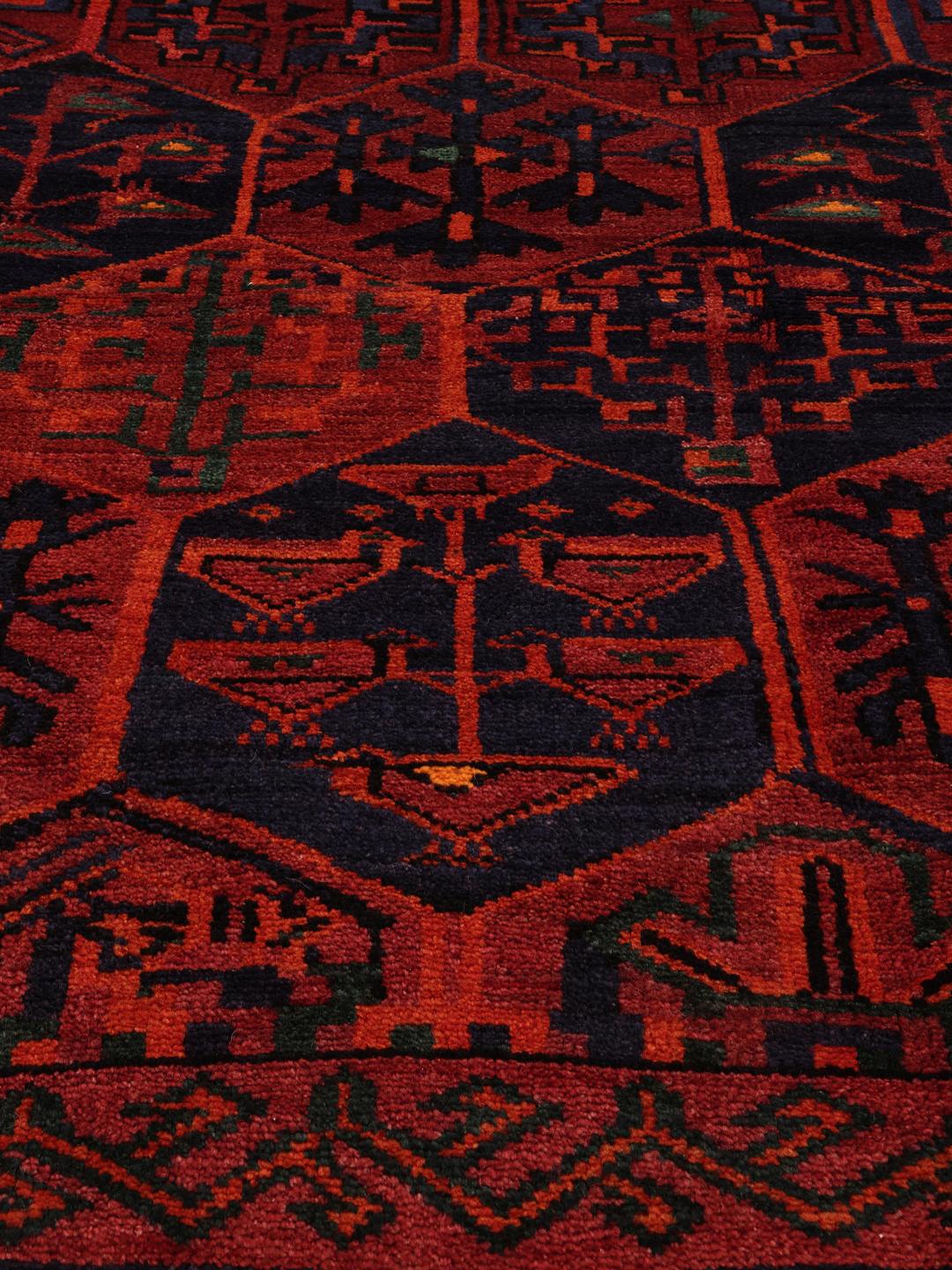 Hand-knotted Lori rug from the Middle East featuring a deep red base with geometric motifs