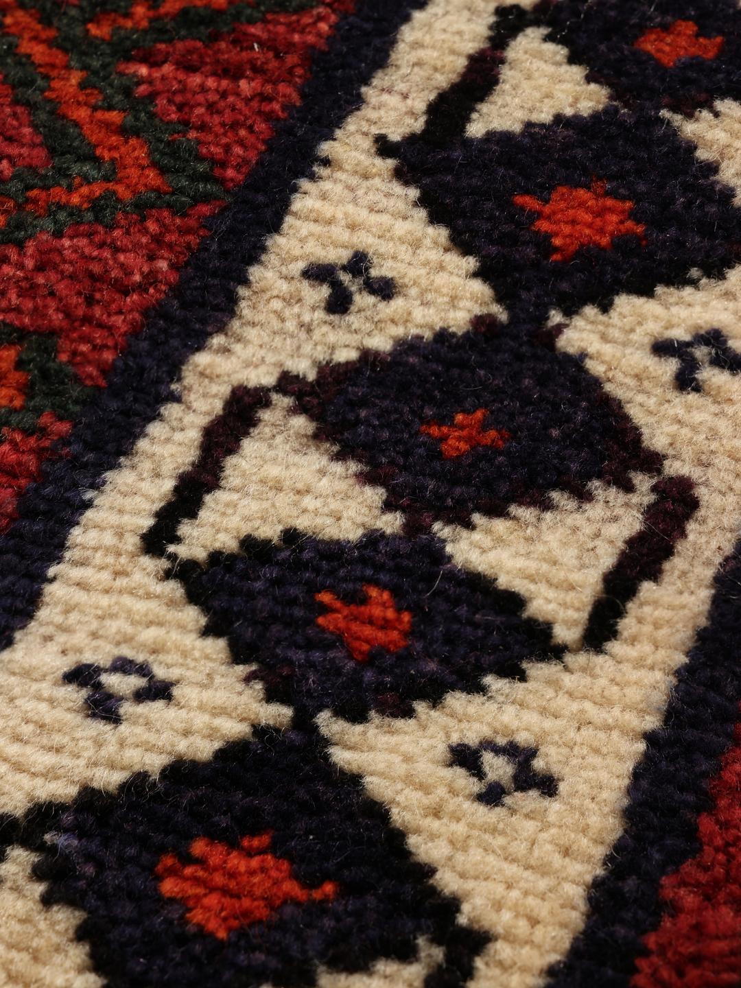 Hand-knotted Lori rug from the Middle East featuring a deep red base with geometric motifs