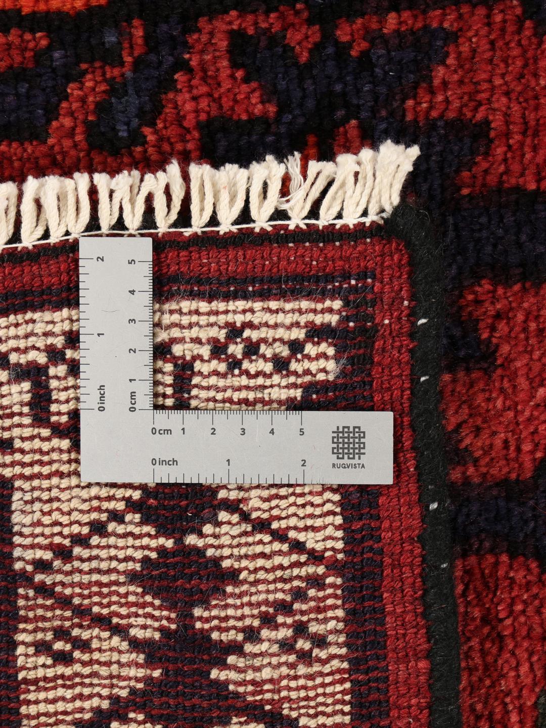 Hand-knotted Lori rug from the Middle East featuring a deep red base with geometric motifs