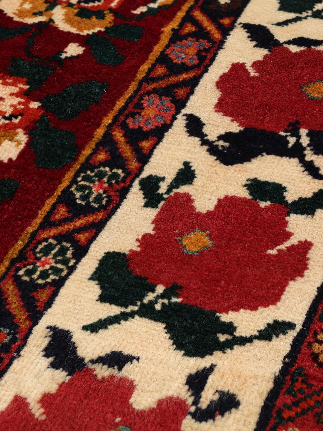 Hand-knotted Ghashghai rug from the Middle East featuring a floral pattern on a red wool background