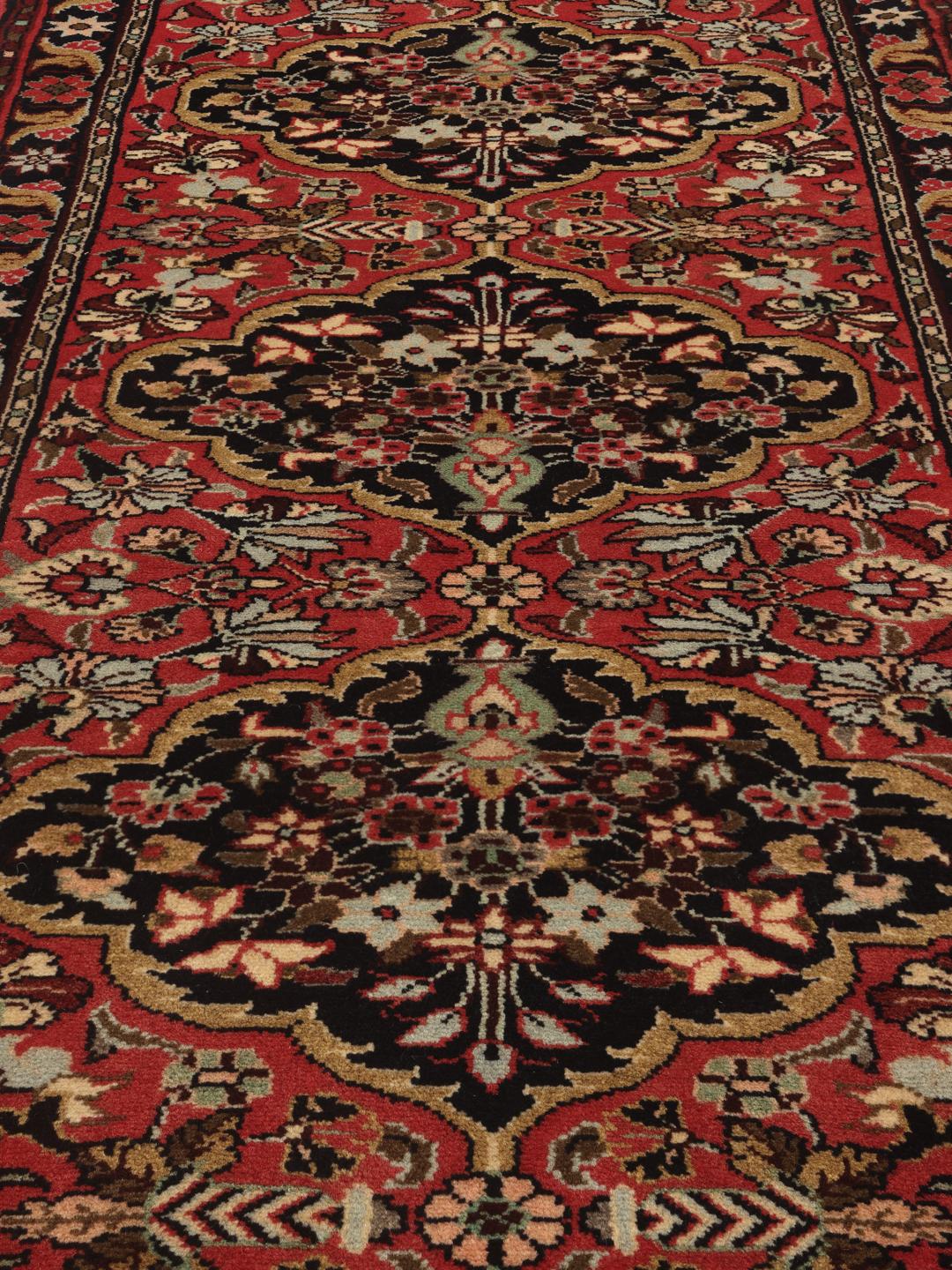 Tapis couloir Mehraban noué à la main dans des tons rouges et sombres avec des motifs floraux