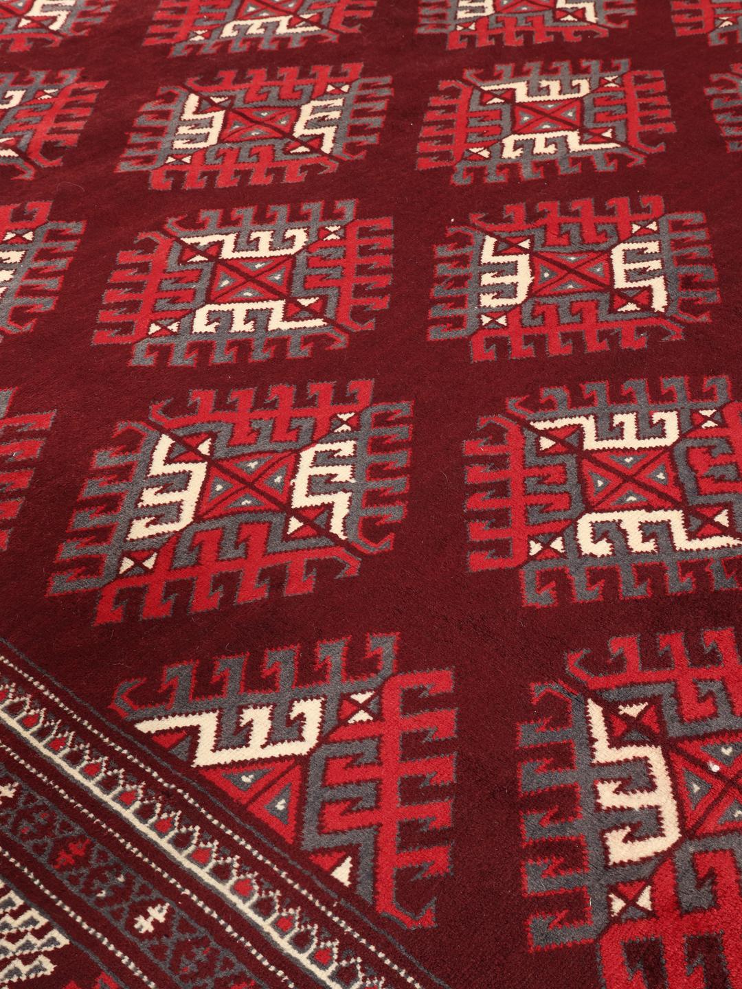 A hand-knotted Turkaman rug from the Middle East in shades of dark-red.