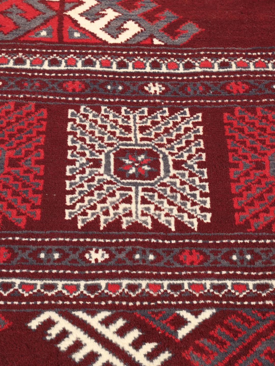 A hand-knotted Turkaman rug from the Middle East in shades of dark-red.