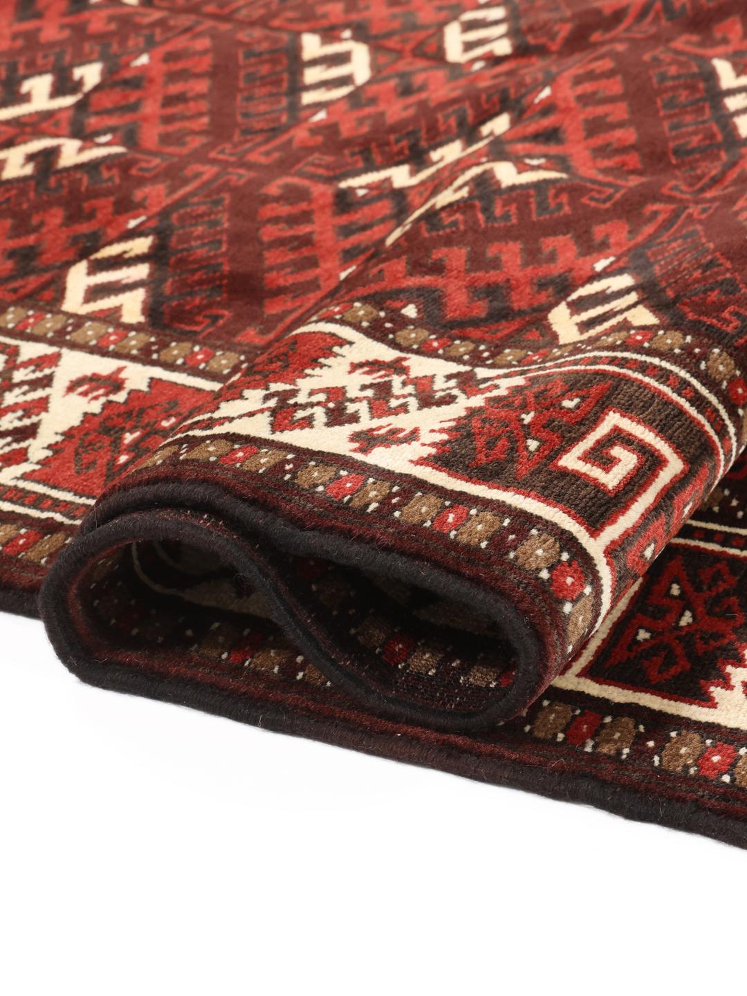 A hand-knotted Turkaman rug from the Middle East featuring a dark-red field and geometric patterns.