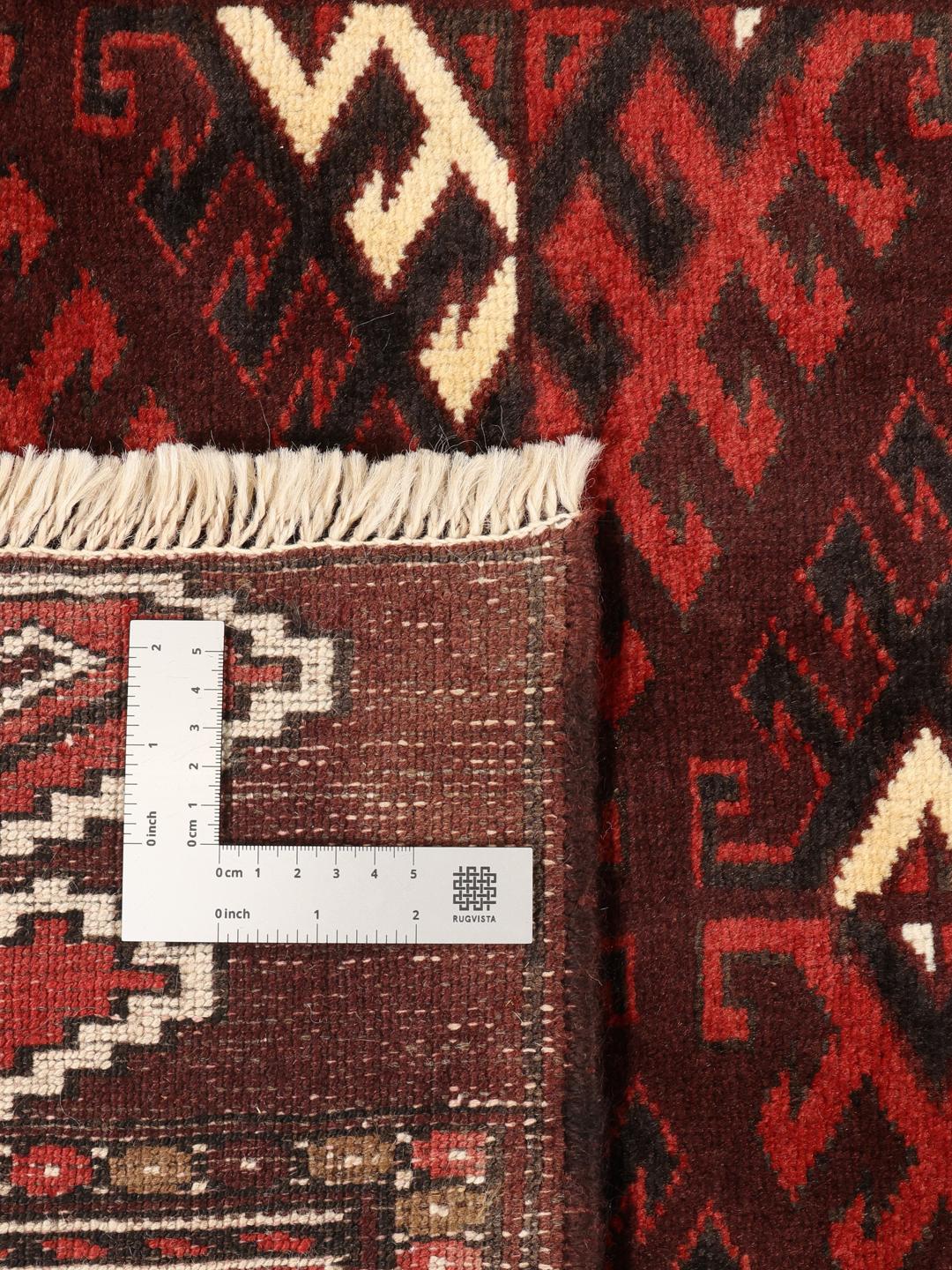 A hand-knotted Turkaman rug from the Middle East featuring a dark-red field and geometric patterns.
