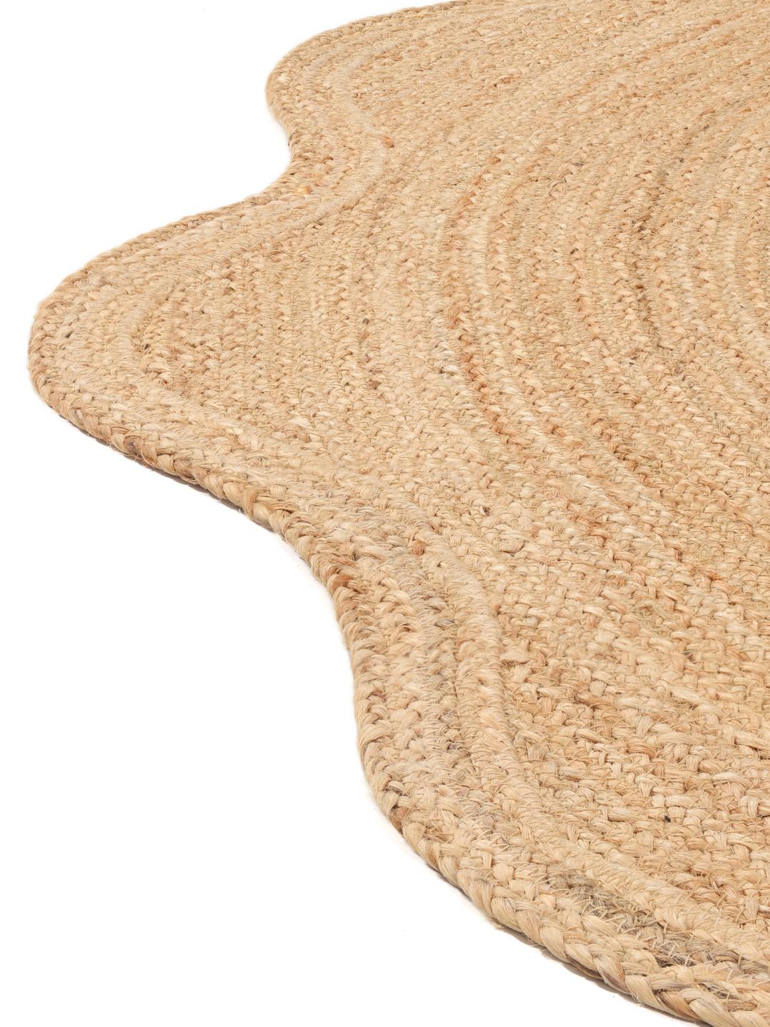 Rundt beige tæppe med bølget kant vævet af naturlig jute