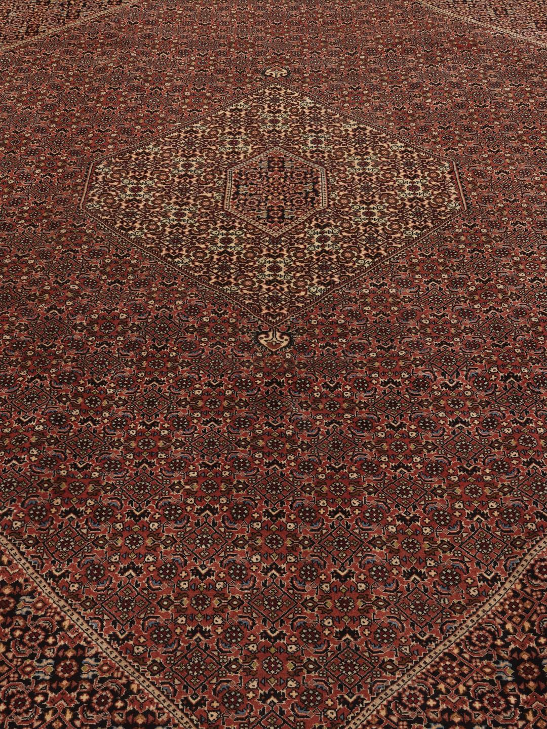 A hand-knotted Bidjar rug from the Middle East with a dark-red field and intricate medallion pattern.