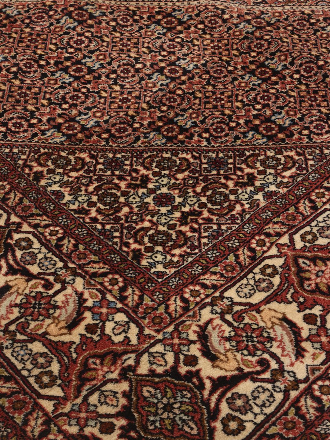 A hand-knotted Bidjar rug from the Middle East with a dark-red field and intricate medallion pattern.