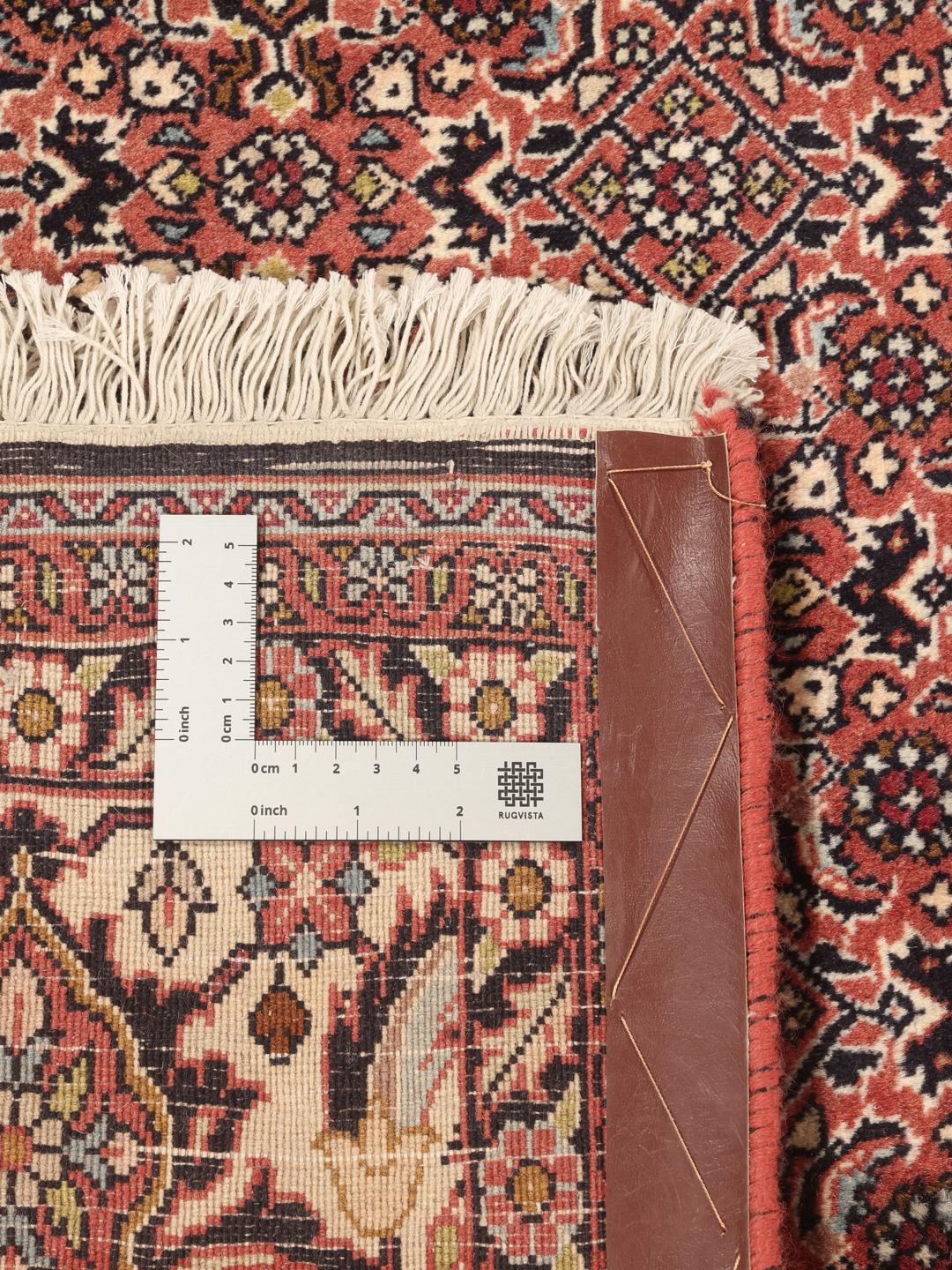 A hand-knotted Bidjar rug from the Middle East with a dark-red field and intricate medallion pattern.