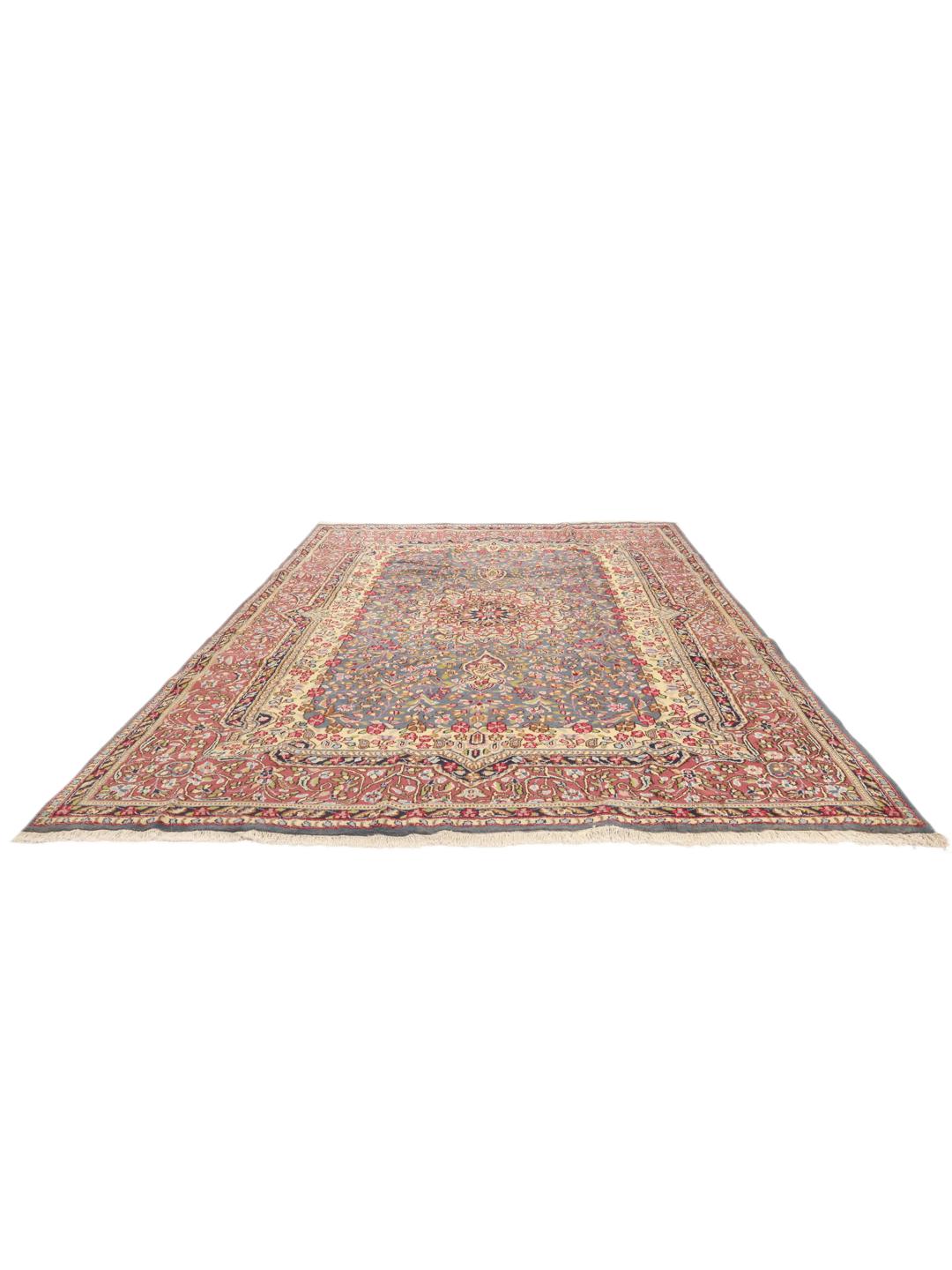 Handgeknoopt Kerman-tapijt met een blauw bloemenmedaillon en rode rand