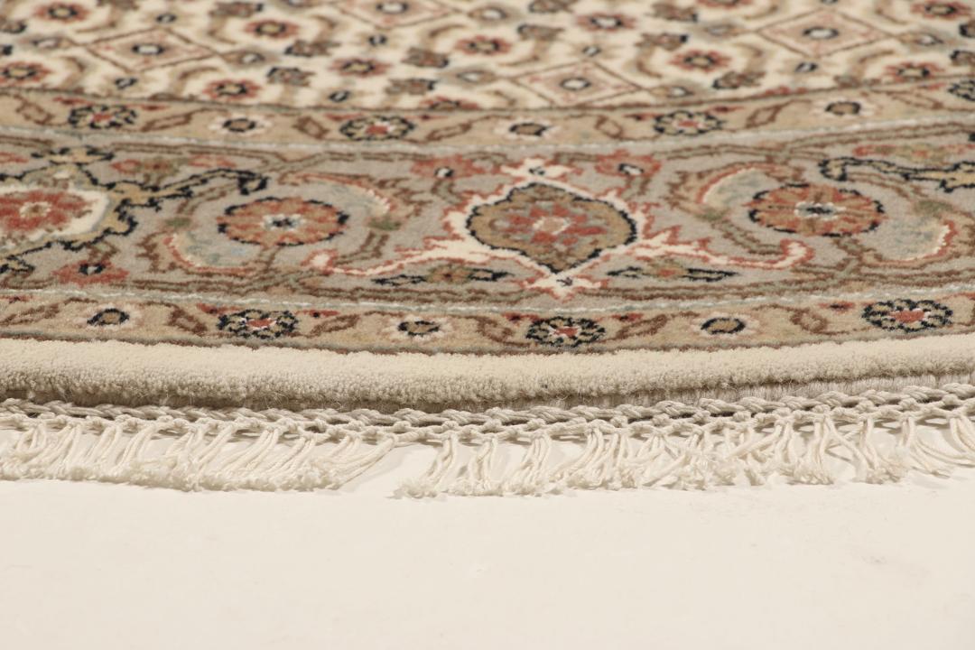 Rundt Tabriz-tæppe med indviklede mønstre i beige, brun og rød, håndlavet i Indien.