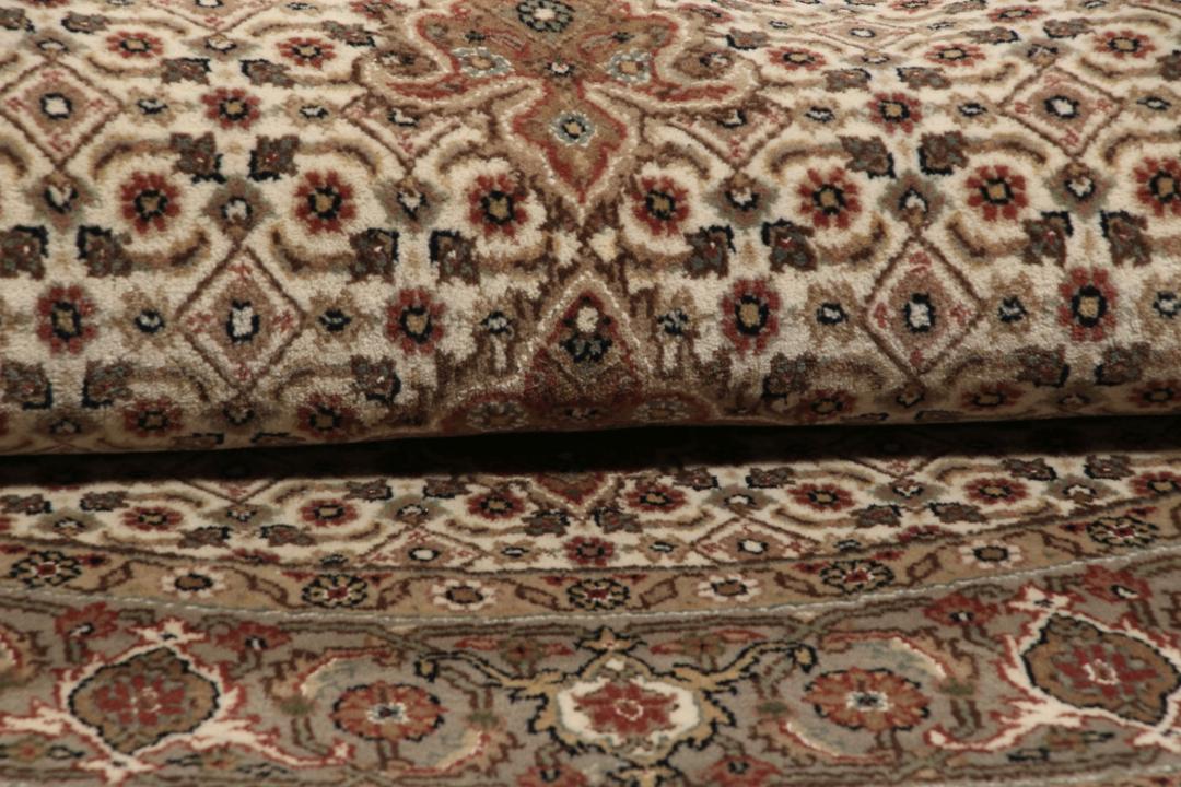 Rundt Tabriz-tæppe med indviklede mønstre i beige, brun og rød, håndlavet i Indien.