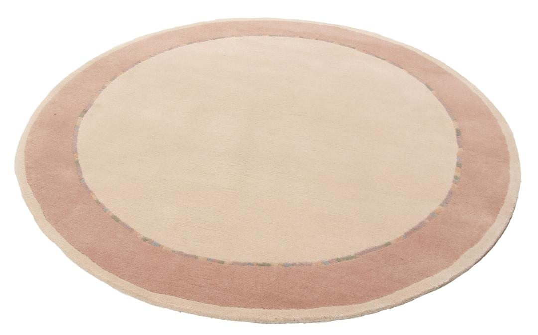 Een rond, uniek Wool tapijt uit Nepal met een minimalistisch beige en zachtroze ontwerp.