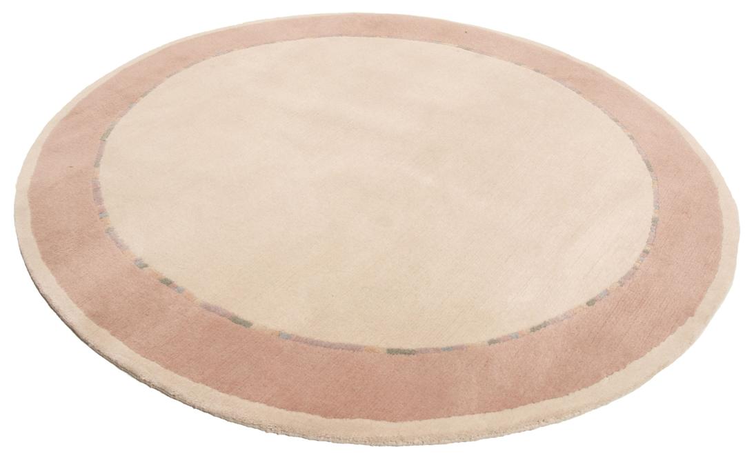 Een rond, uniek Wool tapijt uit Nepal met een minimalistisch beige en zachtroze ontwerp.
