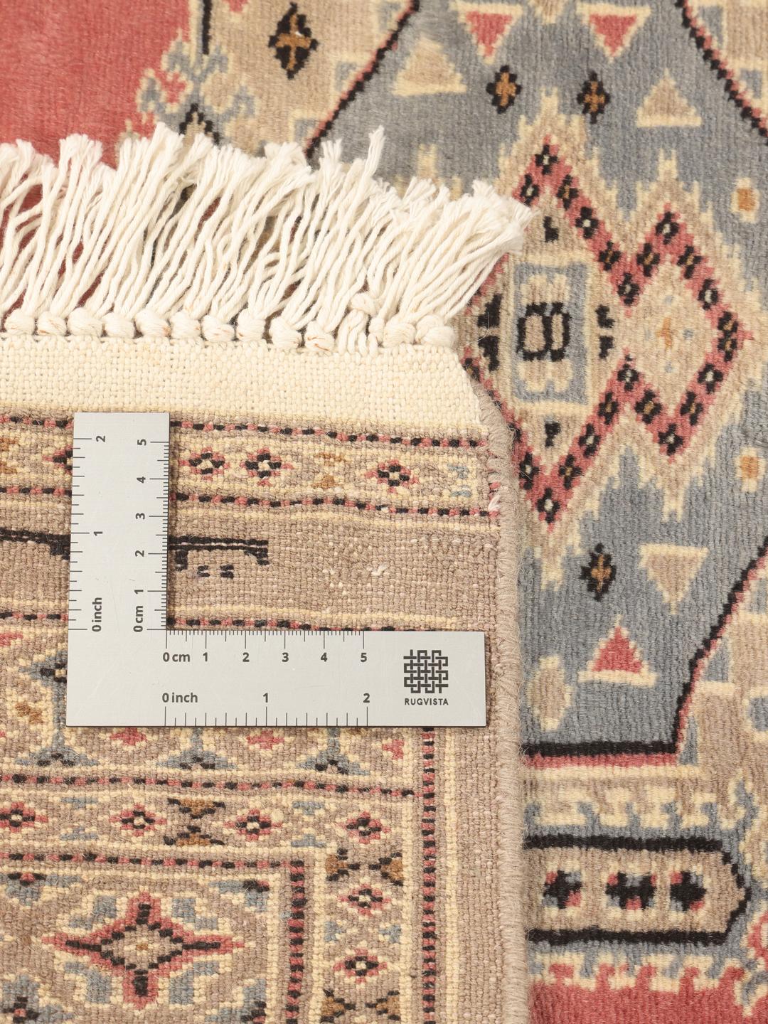 Hand-knotted Pakistan Bokhara rug with a red field and traditional medallion patterns.