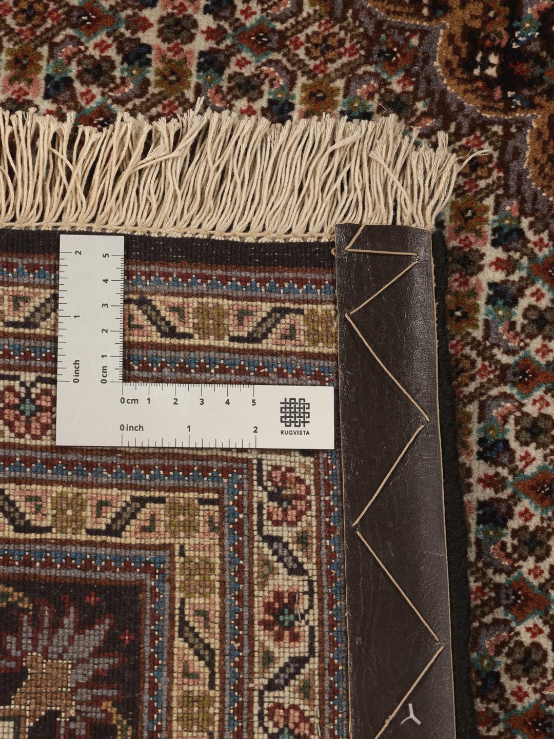Et håndknyttet Tabriz-tæppe fra Mellemøsten med et brunt og rødt medaljonmønster.