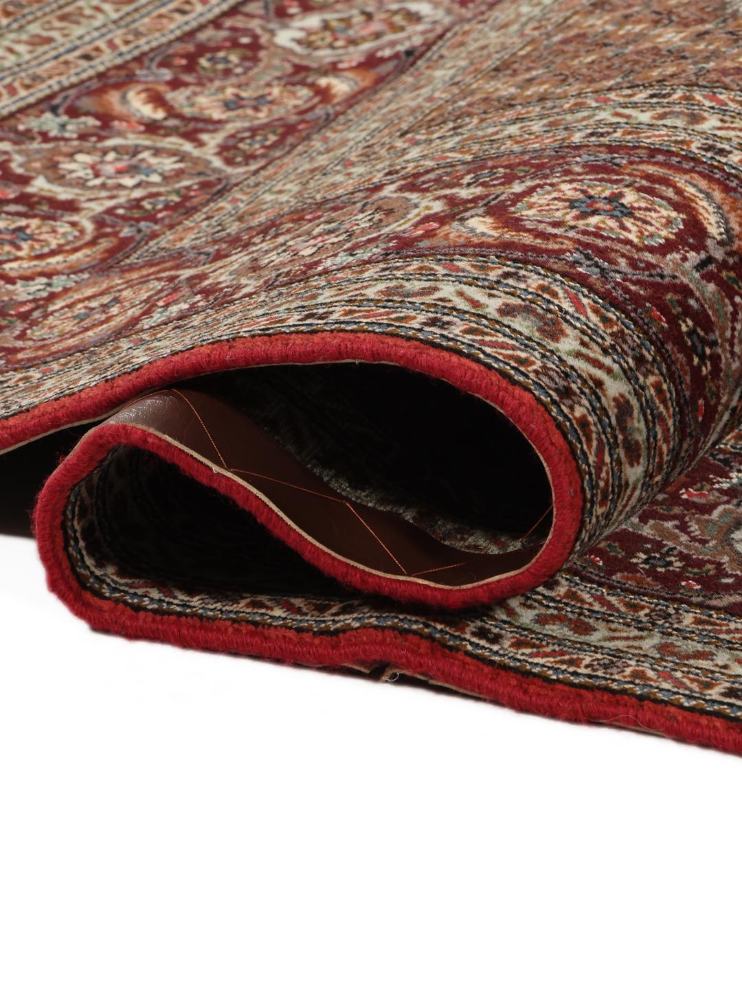 Et håndknyttet Tabriz-tæppe fra Mellemøsten med et detaljeret rødt og beige mønster